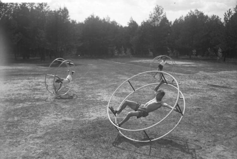 Altes Bild mit drei Sportlern auf ihren Rhönrädern